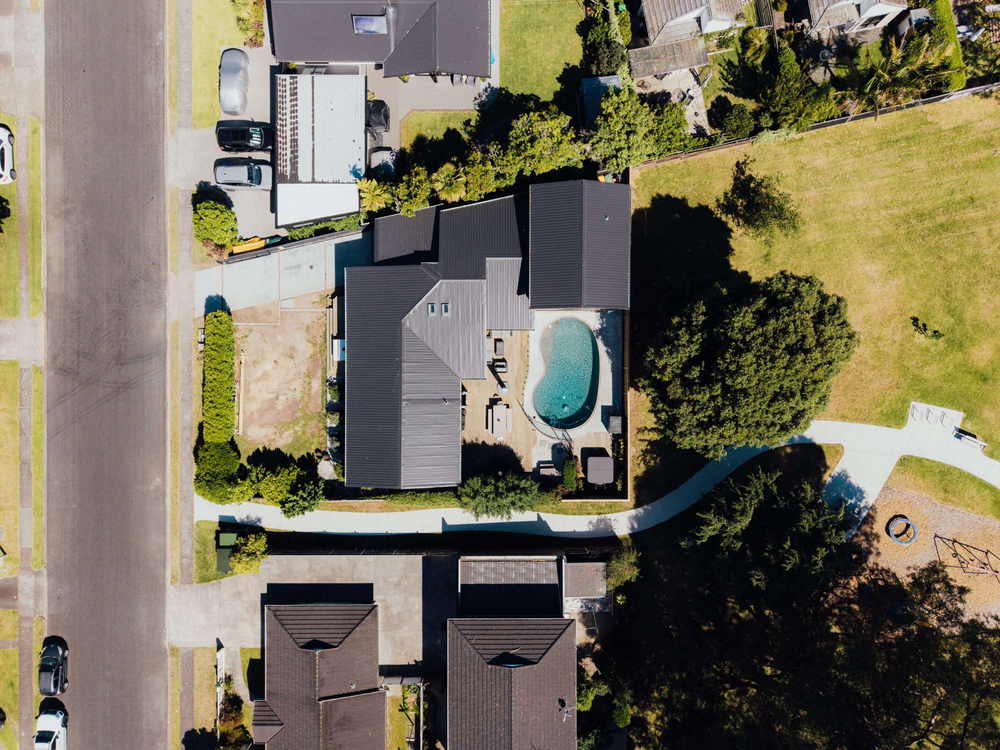 Straight down aerial of a Tauranga house with a new dark roof, pool and lawn
