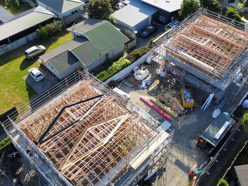 Aerial view of a new build with the roof trusses up and scaffolding around the perimeter