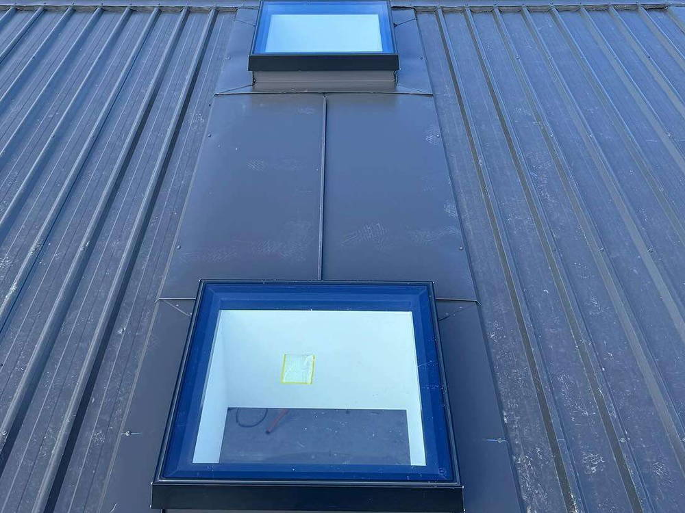 Two skylights set into a dark standing seam roof