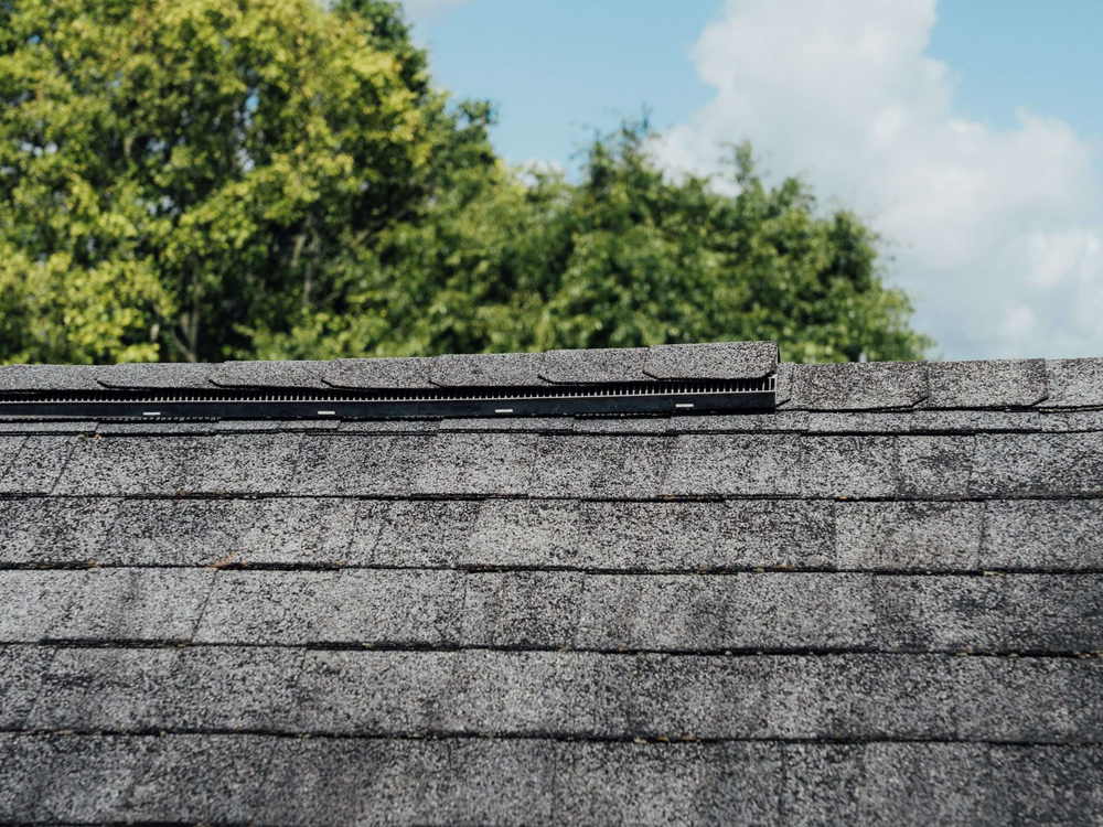 Close view of asphalt shingle courses laid up a roof slope