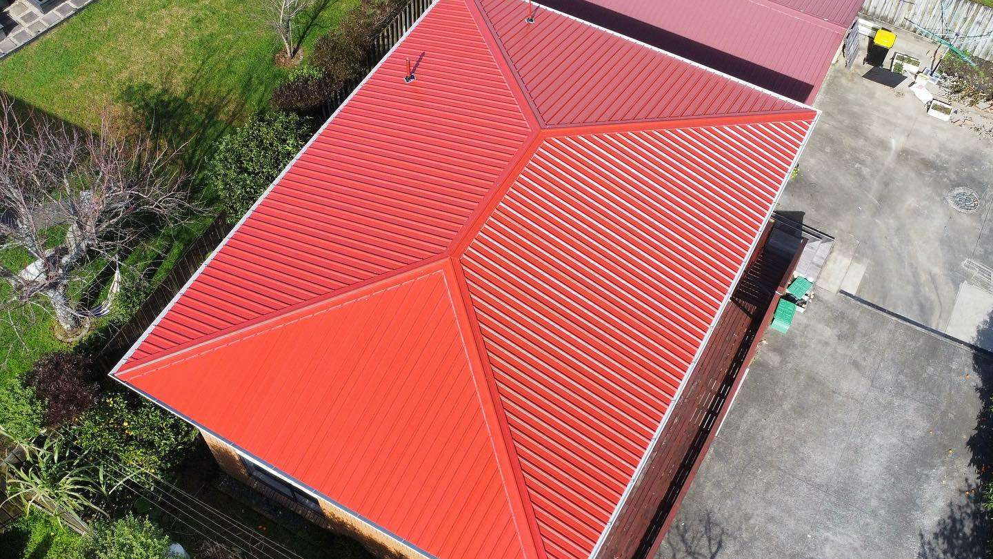 Aerial view of a long hip roof finished in bright orange red, seen from directly above