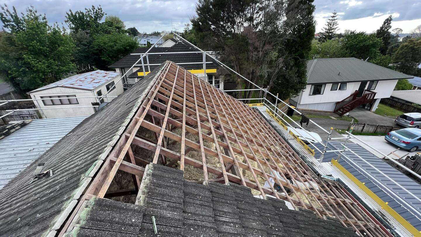 Failed roof stripped back along the ridge with the purlins and framing exposed to the sky