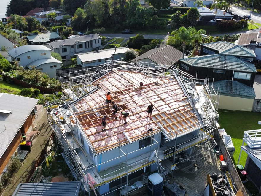 Aerial view of a new build in Tauranga with the roof framing exposed and scaffolding in place